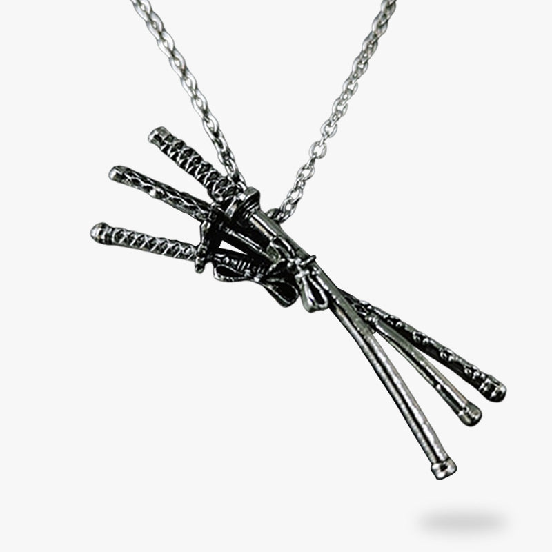 Ce collier katana se compose de trois sabres japonais attachés au bout d'une chaine en argent