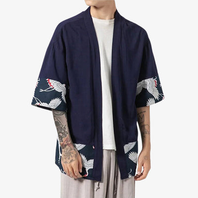 Ce kimnoo haori homme traditionnel est de couleur bleu marine. Des motifs de grues tsuru sont imprimés sur l'extremité de la veste japonaise homme