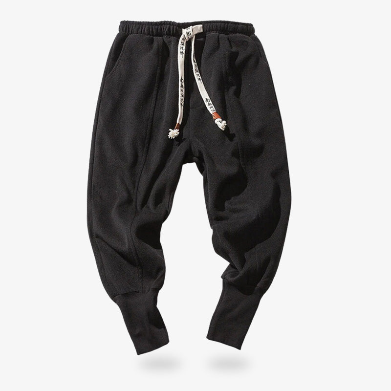 Ce pantalon noir japonais est parfait pour une garde robe streetwear, casual et zen. Pantalon japonais qui se noue avec des cordons aux motifs imprimé style Kanji