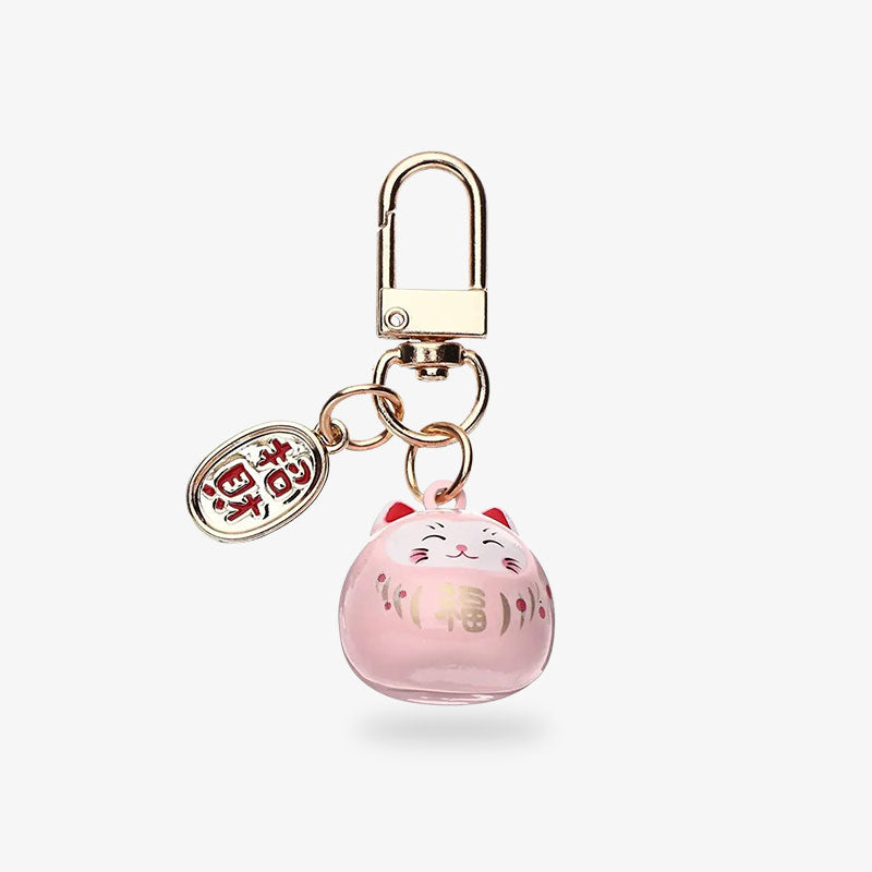 Ce porte clés maneki neko est de couleur rose avec un kanji est une pièce dorée avec un kanji japonais