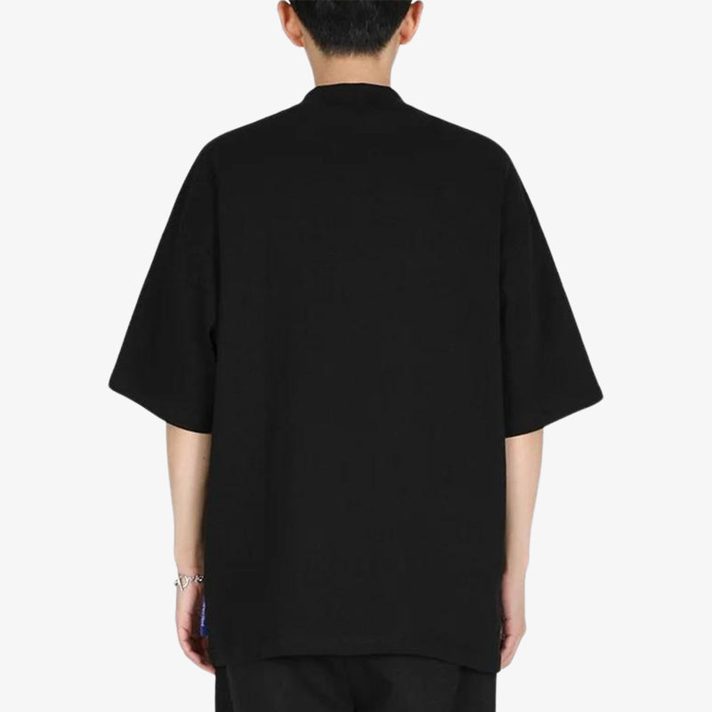 Un homme porte un T-shirt japonais noir au style minimaliste monochrome, avec une coupe oversize inspirée de la mode Jpop et du streetwear japonais