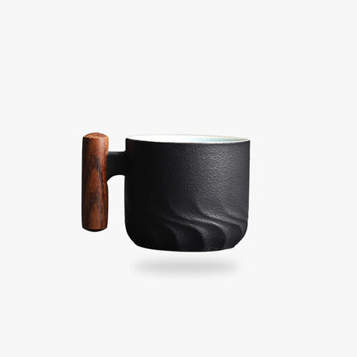 une tasse japonaise ancienne avec un manche en bois. Tasse en céramique de couleur noir