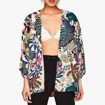 Un fille porte une veste kimono femme fleurie avec un top blanc et un jean noir